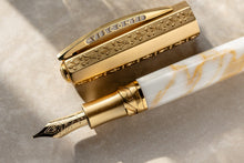 Load image into Gallery viewer, Close up to the cap and fountain pen grip section on the Visconti Il Magnifico Calcatta Gold