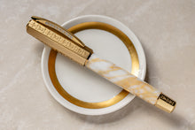Load image into Gallery viewer, Visconti Il Magnifico Calcatta pen laid on a small white plate with the cap on.