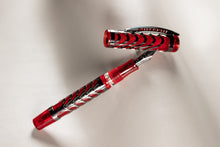 Load image into Gallery viewer, The Visconti skeleton ruby red fountain pen and Cap arranged on a light gray background.