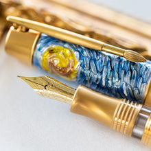 Load image into Gallery viewer, Close up to the yellow gold nib and the paintbrush-shaped clip of the pen. The cap has a casting design with blues and yellows representing Van Gogh's Starry Night.