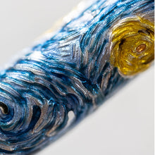 Load image into Gallery viewer, Close up to the casting on the pen. it is designed with brush-stroke like marks in blue, white, and yellow.