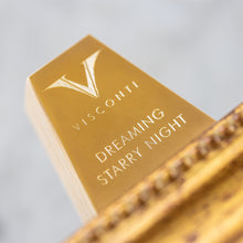 Load image into Gallery viewer, Close up to the engraving on the top of the easel which holds the pen. It has the Visconti logo and DREAMING STARRY NIGHT underneath.