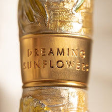 Load image into Gallery viewer, Close up to the cap ring. Set on a blurry background. The engraving reads: DREAMING SUNFLOWERS.