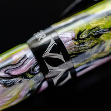 Load image into Gallery viewer, Close up to the cap ring on the Visconti Voyager Mariposa malachite. it has black trims, and the resin swirls are pink, black, and green.