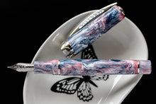 Load image into Gallery viewer, The Visconti Voyager Mariposa Fountain Pen laid on a white plate with a black butterfly design print.