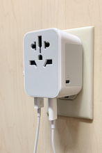 Load image into Gallery viewer, The adapter connected to a wall plug. The different connection options are shown.