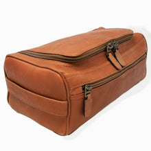 Load image into Gallery viewer, angled view of a tan leather toiletry bag with multiple compartments and dark metal zippers