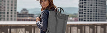 Load image into Gallery viewer, A young woman carrying the tote backpack from the same line.