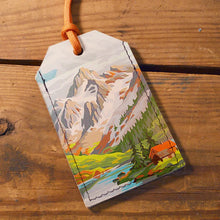 Load image into Gallery viewer, Luggage tag with mountain landscape design on a wooden surface
