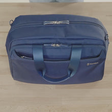 Load and play video in Gallery viewer, A woman fills the blue version of the bag with clothes and travel accessories.