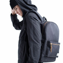 Load image into Gallery viewer, A young man carrying the black backpack.