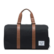 Load image into Gallery viewer, Front view of the duffle bag with a white Herschel logo tag.