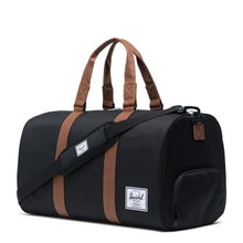 Load image into Gallery viewer, Angled front view of the black duffle bag with the shoulder strap attached.