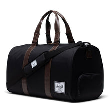 Load image into Gallery viewer, Angled front view of the black chicory coffee duffle bag. The shoulder strap is laid across the front.