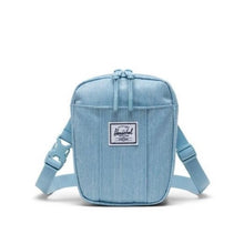 Load image into Gallery viewer, Front view of the light blue denim bag. A small white Herschel logo tag is sown at the front.