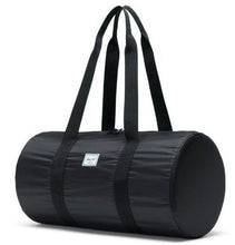 Load image into Gallery viewer, Angled front view of the black packable duffle bag with the shoulder straps pulled up.