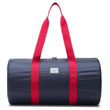 Load image into Gallery viewer, Front view of the navy red duffle bag with the shoulder straps pulled up.