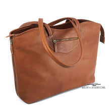 Load image into Gallery viewer, Angled front view of the tan leather tote bag. The shoulder straps are resting across the top.