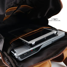 Load image into Gallery viewer, Angled interior view of the tan leather backpack. A laptop and tablet are stored inside the compartments.