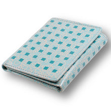 Load image into Gallery viewer, Angled view of the wallet. It is a light blue with a light orange design and a series of darker blue squares. Set on a white background.