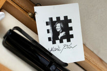 Load image into Gallery viewer, Close up to the included tag. It features a portrait of Andree Putman.