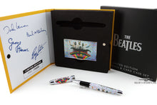 Load image into Gallery viewer, View of the Magical Mystery Tour pen and card case set with the outer box and presentation box. The rollerball has the Magical Mystery Tour logo on it and the portrait of the band in their costumes is on the barrel. Set on a white background.