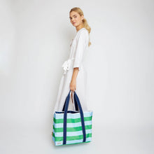 Load image into Gallery viewer, Tote in blue and green straps being held by a Model. Placed on a white background.
