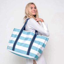 Load image into Gallery viewer, Ame & Lulu Sun & Sea Tote in blue and white held b a model.