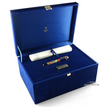 Load image into Gallery viewer, The presentation box opened with the fountain pen in its designated slot with an included white scroll, closed with a blue ribbon. The plate next to the pen features an engraving that reads "Jules Verne". The lid has a small plate in the shape of an anchor.