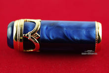 Load image into Gallery viewer, Close up to the cap, set on a red background. The trims are in the shape of decorations and gold-plated.