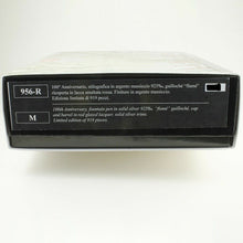 Load image into Gallery viewer, Side view of the outer box on a white background. The text reads: 
"956 R, M, 100th Anniversary fountain pen in solid silver 025%, "flame" guilloche, cap and barrel in red glazed lacquer, solid silver trims. Limited Edition of 919 pieces." The translated text in Italian is printed above.