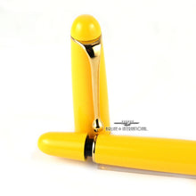 Load image into Gallery viewer, Close up to the end of the pen with the cap placed behind it. The piston is pulled out. Set on a white background.