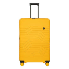 Load image into Gallery viewer, Front view of the mango yellow suitcase with black accents. The front panel has a wave lines design with a small circular black logo at the top right. The telescopic handle is pulled up.