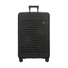 Load image into Gallery viewer, Front panel view of a matte black hard-shell suitcase with a textured wave pattern. It has a telescopic handle, and a small circular logo at the top right.