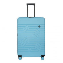 Load image into Gallery viewer, Front view of the light blue hard shell suitcase with black trims. It has a wave line design and a small circular black logo on the top right. The telescopic handle is pulled up.