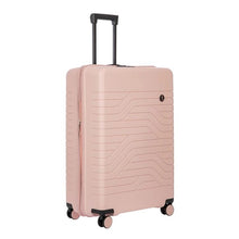 Load image into Gallery viewer, A matte, hard-shell pink  suitcase with a textured wave pattern on the front. It has four spinner wheels, a retractable black handle on top and a small circular logo with the letters BV on the front.