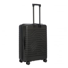 Load image into Gallery viewer, Angled back view of the black hard shell suitcase. The panel features a textured wave lines design and a handle on the left side. The telescopic handle is pulled up.