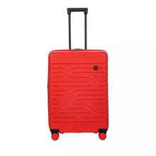 Load image into Gallery viewer, Front view of the red hard shell suitcase with black accents. The front panel has a wave lines design and a small circular logo with the BY letters at the top right.