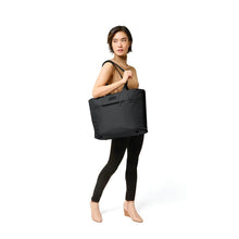 Load image into Gallery viewer, Briggs & Riley Baseline Travel Tote - Black
Image of Travel Tote shown on female model's shoulder
Height	     Width	     Depth	     Weight
US	13 in.      21 in.       7.5 in.     1.6 lbs.
EU	33 cm    53.3 cm	19.1 cm	0.7 kg