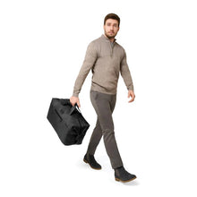 Load image into Gallery viewer, Briggs & Riley Baseline Weekender Duffle - Black
Image of male model carrying the Weekender Duffle
Height	    Width	    Depth	    Weight
US	15.5 in.	20 in.     9 in.	      2.5 lbs.
EU	39.4 cm	50.8 cm	22.9 cm	1.1 kg