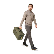 Load image into Gallery viewer, Briggs & Riley Baseline Weekender Duffle - Olive
Image of male model carrying weekender duffle
Height	    Width	    Depth	    Weight
US	15.5 in.	20 in.     9 in.	      2.5 lbs.
EU	39.4 cm	50.8 cm	22.9 cm	1.1 kg