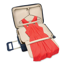 Load image into Gallery viewer, Briggs & Riley Baseline Essential 2-Wheel Carry-On - Navy
Image of tri-fold garment folder in lid compartment with roll bar to minimize wrinkling. Shown with full length dress in hanging position.
Height	     Width	     Depth	     Weight
US	22 in.	14 in.	9 in.	        9.7 lbs.
EU	55.9 cm	35.6 cm	22.9 cm	4.4 kg