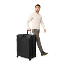 Load image into Gallery viewer, Image of Front Angled View of Extra-Large Expandable Spinner being wheeled by male model.