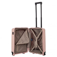 Load image into Gallery viewer, Interior view of the pearl pink hard shell suitcase with black accents. The fabric lining is light brown. The front panel's side has a zipper-closing compartment. The back panel's side has a set of straps to hold contents in place.