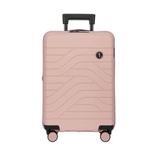 Load image into Gallery viewer, Front view of the pearl pink hard shell suitcase with black accents. The panel has a textured wave lines design, and a small black circular logo at the top right. The telescopic handle is partly pulled up.