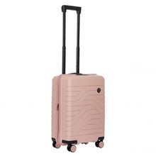 Load image into Gallery viewer, Angled front view of the pearl pink hard shell suitcase with black accents. The front panel has a textured wave lines design, and a small black circular logo at the top right. The telescopic handle is pulled up.