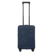 Load image into Gallery viewer, Front view of the navy blue hard shell suitcase with black accents. The panel has a textured wave lines design, and a small black circular logo at the top right. The telescopic handle is fully extended.