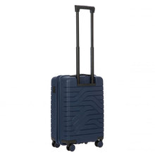 Load image into Gallery viewer, Angled back view of the light blue  hard shell suitcase with black accents. The back panel has a textured wave lines design. The telescopic handle is fully extended.