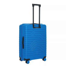 Load image into Gallery viewer, Angled back view of the electric blue suitcase with black accents. The panel has a textured wave lines design. The left side features a black handle for easy grabbing. The telescopic handle is pulled up.