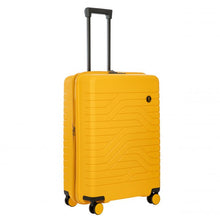 Load image into Gallery viewer, 
Angled front view of the mango yellow hard shell suitcase with black accents. The front panel has a textured wave lines design, and a small black circular logo at the top right. The telescopic handle is pulled up.